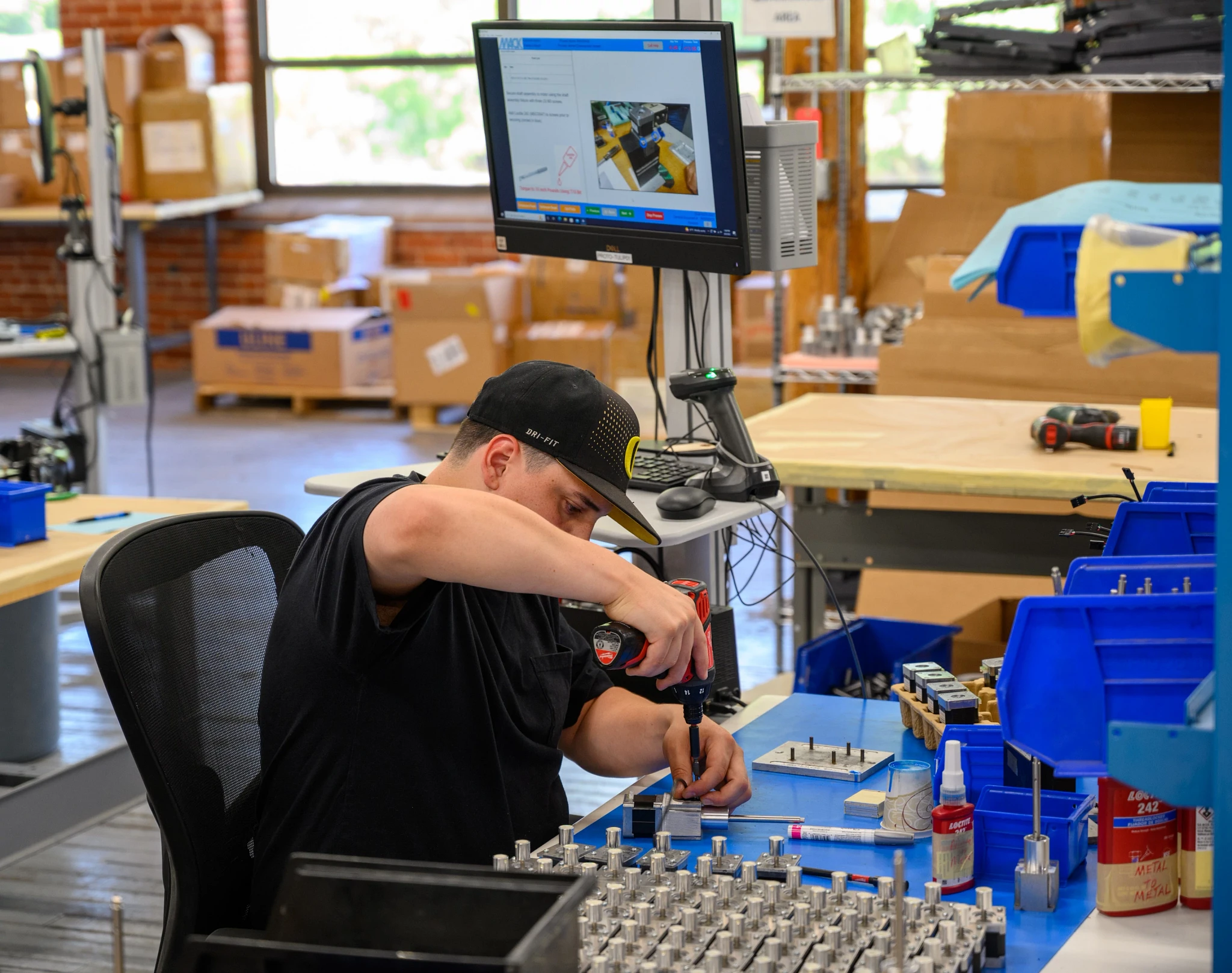 CUST-Mack-Molding-worker-drilling-on-workbench.webp
